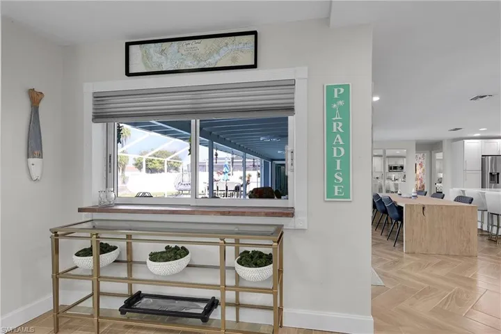 Sliding glass window with a wood-finish sill and a pleated shade