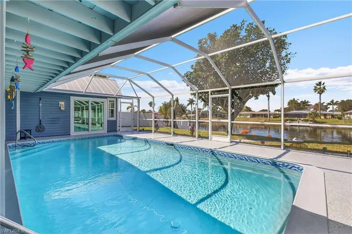 Screened-in pool deck featuring a swimming pool, concrete decking, and direct access to the interior via glass sliding doors
