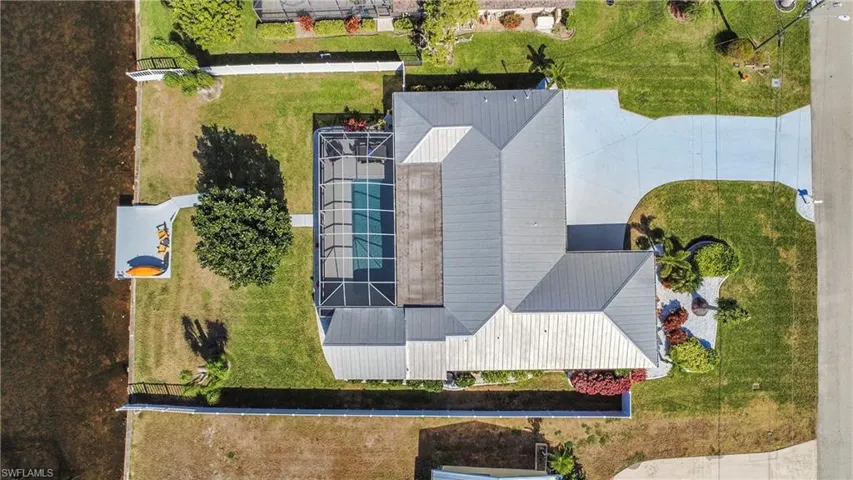 Waterfront property featuring a screened-in swimming pool, private dock, and a multi-gabled roofline