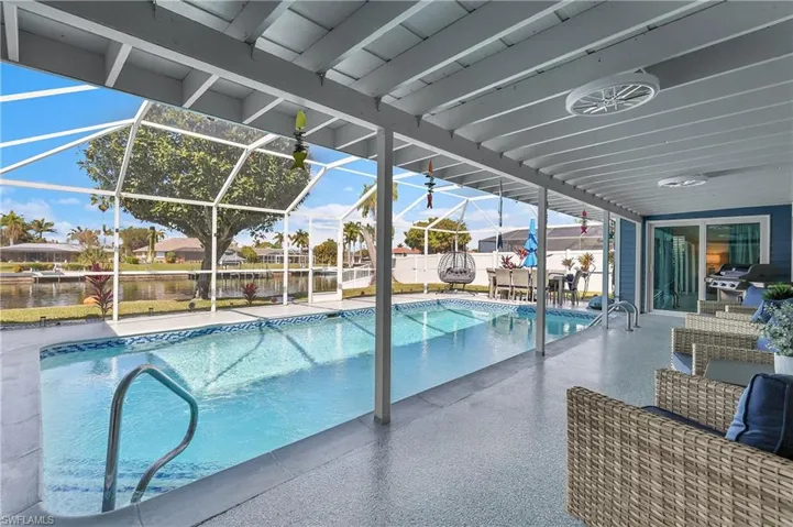 Screened lanai featuring a swimming pool, covered patio, and water frontage