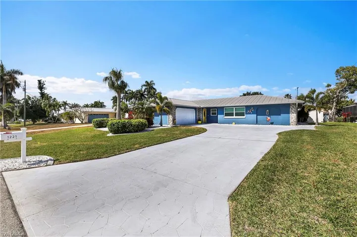 Single-story residence featuring a blue exterior with stone accents and a metal roof