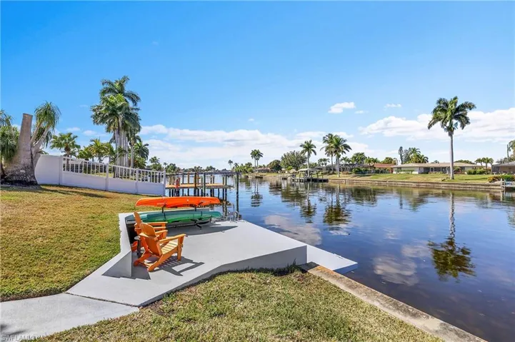 Waterfront property featuring a private dock, concrete seawall, and direct canal access