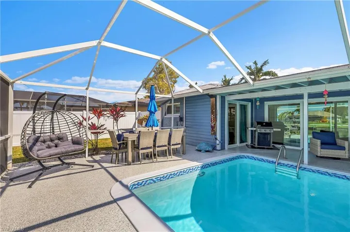 Screened pool enclosure featuring a concrete deck, integrated swimming pool with tiled border, and a covered patio area