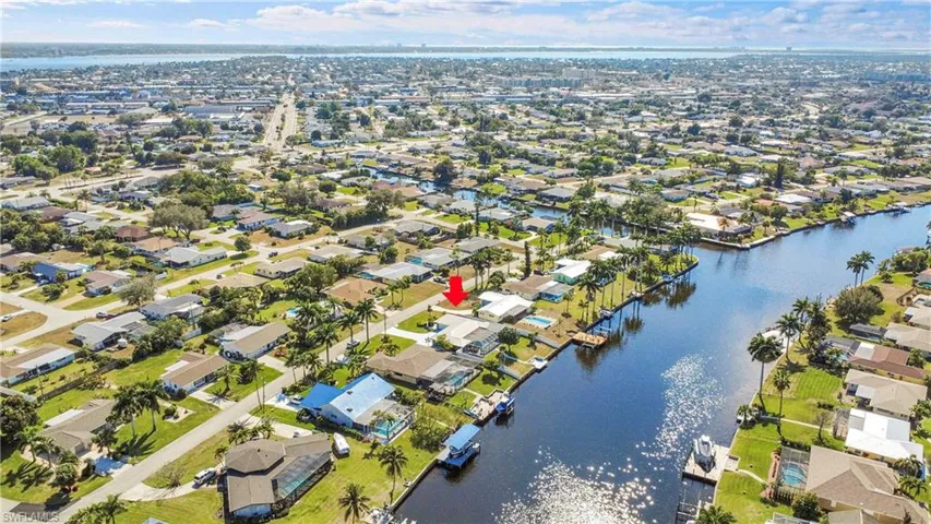 Aerial perspective showcasing a canal-front property within a residential neighborhood