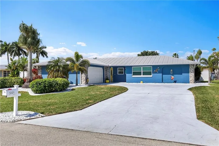 Single-story residence featuring a two-tone blue exterior with stone accents and a metal roof