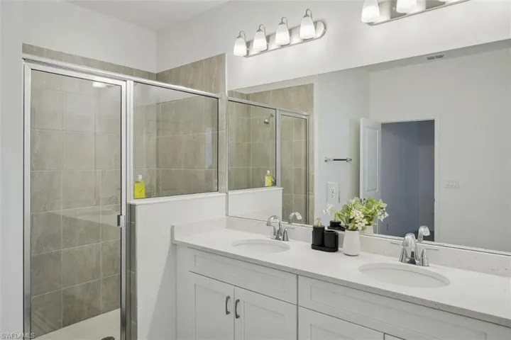 Model Home Virtually staged Full bath with double vanity and a stall shower