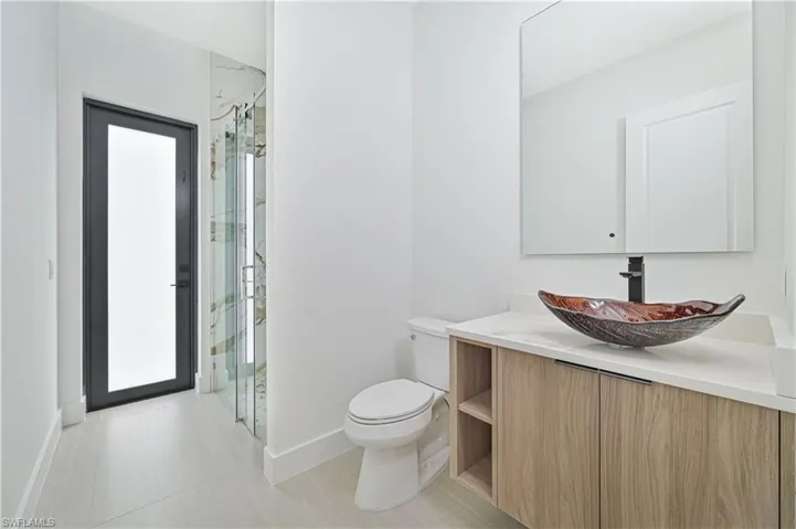 Full bath with vanity and a marble finish shower
