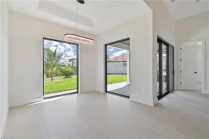 Unfurnished dining area featuring a tray ceiling and hanging lights