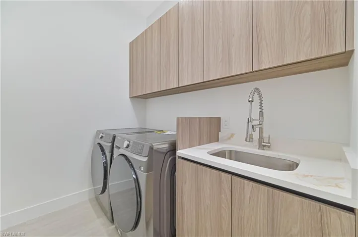 Laundry room featuring separate washer and dryer and cabinet space