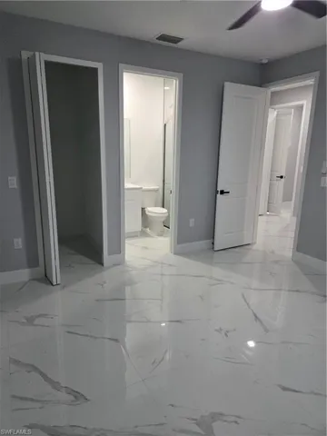 Full bathroom with vanity, light marble finish flooring, and a marble finish shower