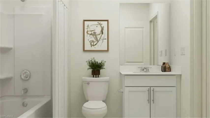 Bathroom featuring a white vanity with cabinet storage, a coordinated white countertop, and a built-in bathtub with an integrated shower