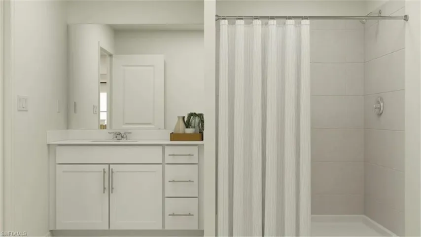 Bathroom featuring a white vanity with integrated sink, chrome faucet, and storage cabinetry