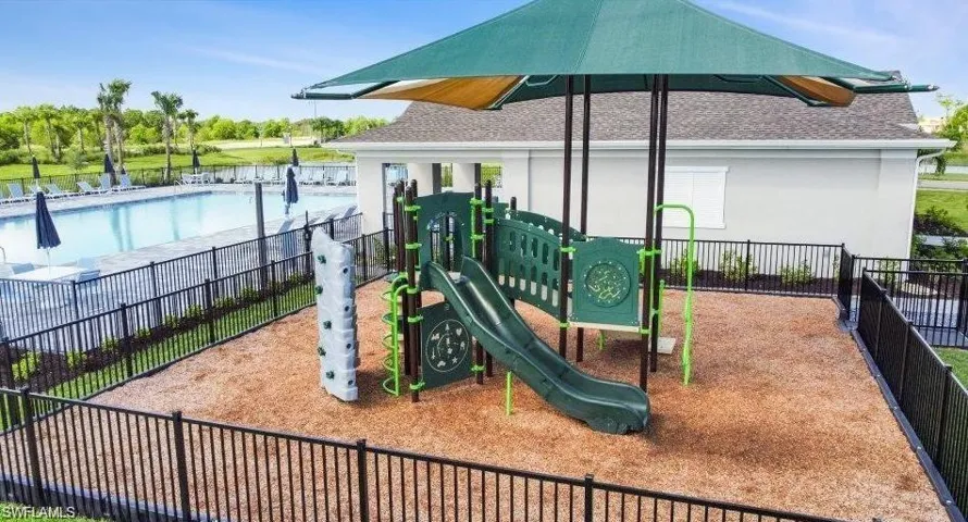 Outdoor playground with a protective shade canopy and wood chip surfacing