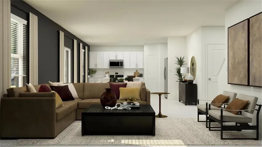 Open-concept living area featuring a kitchen with white cabinetry and stainless steel appliances