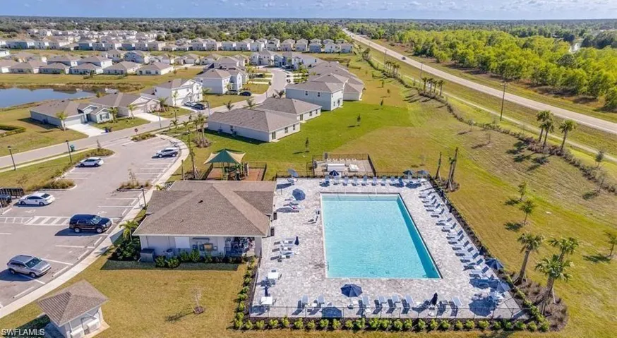 Community swimming pool with a surrounding paver patio and multiple lounge chairs