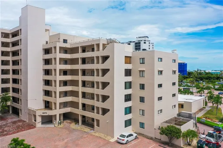 View of apartment building / complex with uncovered parking