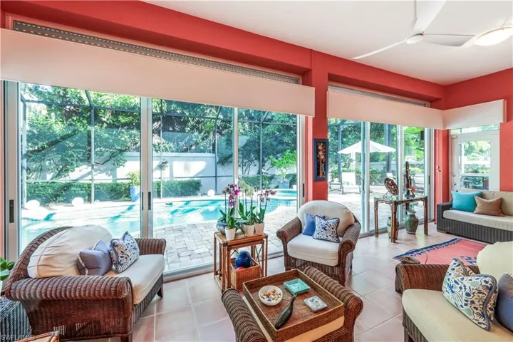 Spacious room featuring multiple sliding glass doors, a ceiling fan, and tile flooring