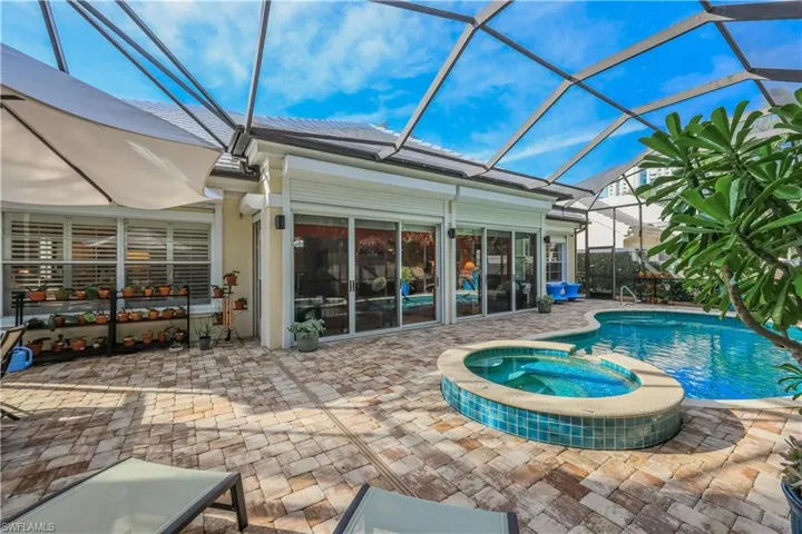 Screened enclosure with a freeform pool and integrated spa