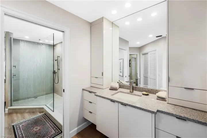 Custom vanity with integrated sink, stone countertop, and contemporary faucet