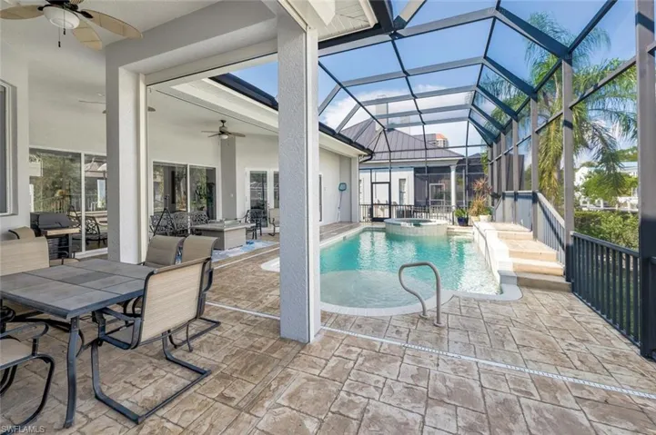 View of pool featuring a lanai, a patio, outdoor lounge area, an in ground hot tub, and ceiling fan