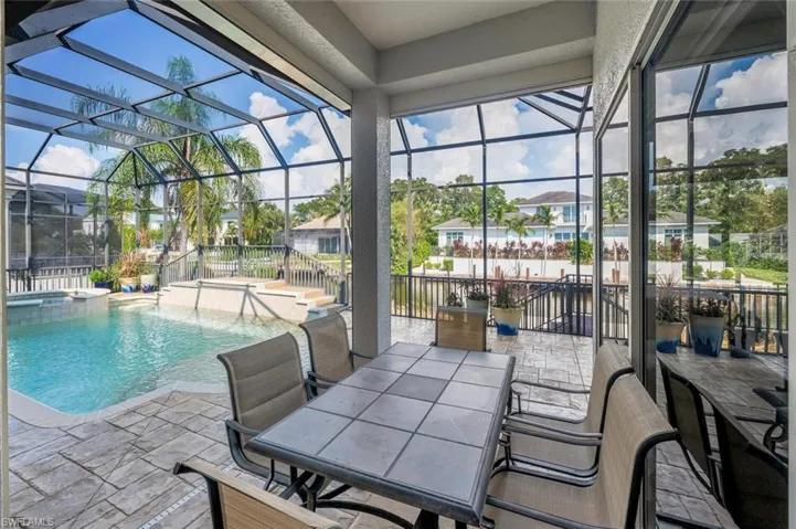 View of swimming pool with a patio, an in ground hot tub, a lanai, and pool water feature
