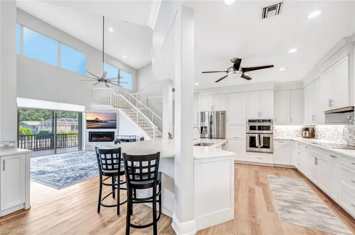 Kitchen with white cabinets, light wood-type flooring, and stainless steel appliances
