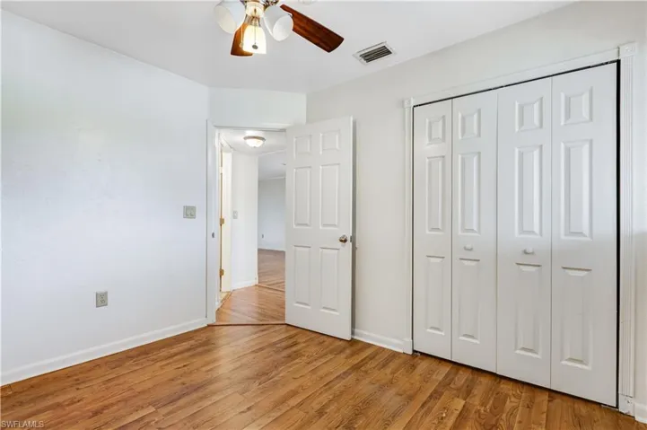 Unfurnished bedroom with light hardwood / wood-style flooring, a closet, and ceiling fan