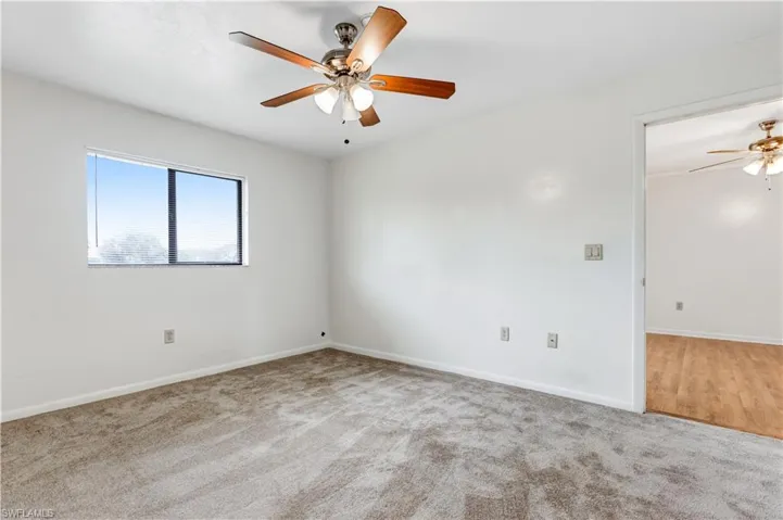 Unfurnished room featuring light colored carpet and ceiling fan