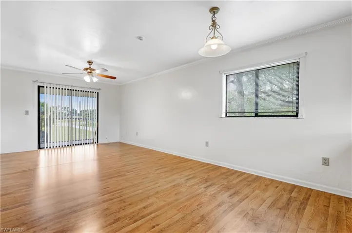Spare room featuring ornamental molding, light wood-type flooring, and ceiling fan