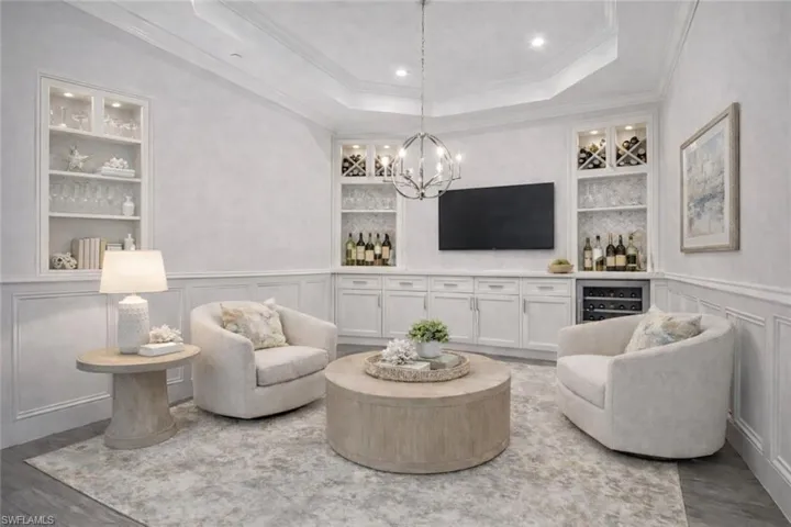 Virtually staged TV/Wine /Dining/Flex Room with beverage cooler, built-in-shelving. Custom Millwork, tray ceiling, crown moulding, and new lighting fixture