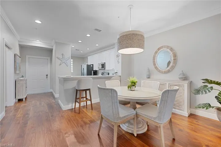 Dining area with crown molding, light wood-type flooring, and recessed lighting