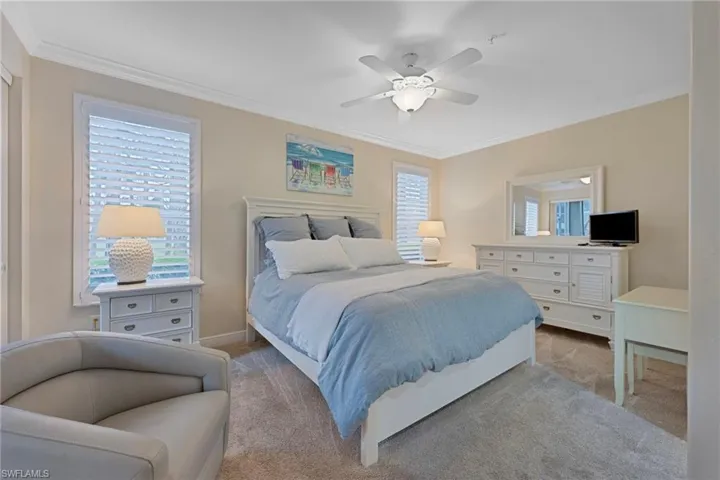 Bedroom featuring crown molding, ceiling fan, and carpet flooring
