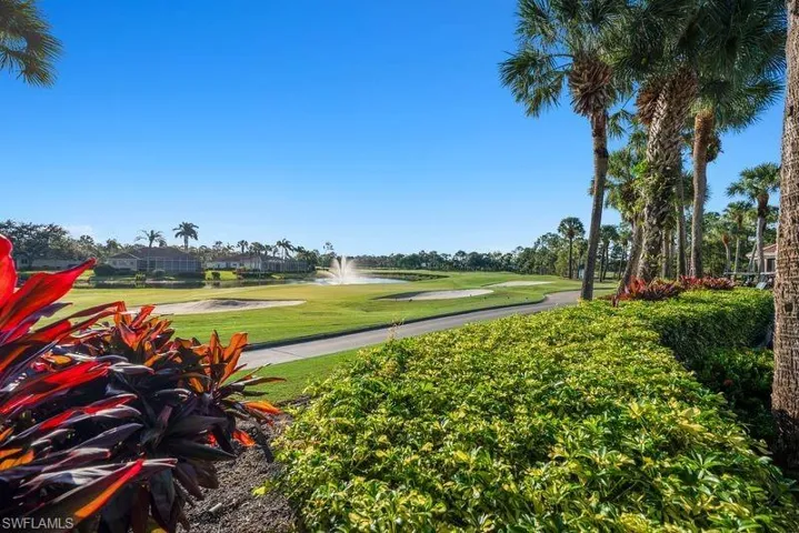 Surrounding community with golf course view, a water view, and a yard