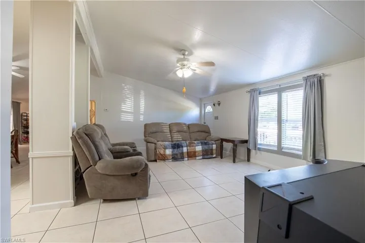 Living room featuring ceiling fan and light tile flooring