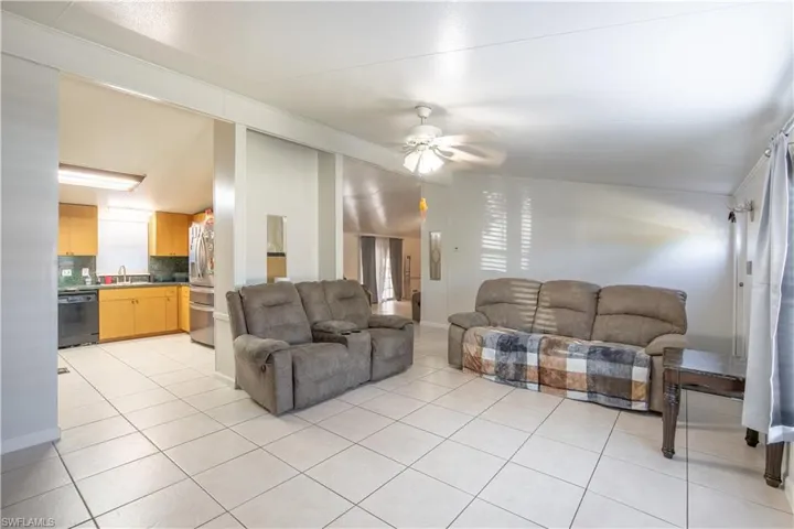 Tiled living room with ceiling fan and sink