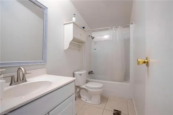 Full bathroom featuring ornamental molding, shower / tub combo, tile floors, large vanity, and toilet