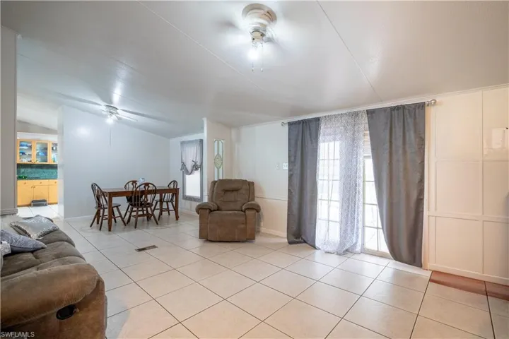 Living room with ceiling fan and light tile floors