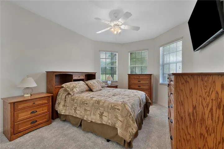 Bedroom with light colored carpet and a ceiling fan