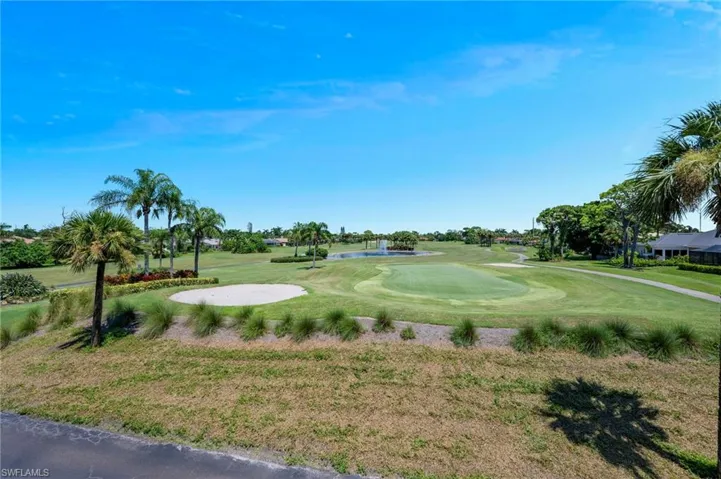View of property's community with a yard, view of golf course, and a water view