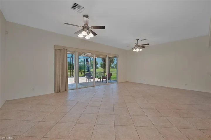 Light tile patterned floors, ceiling fan, and a sunroom