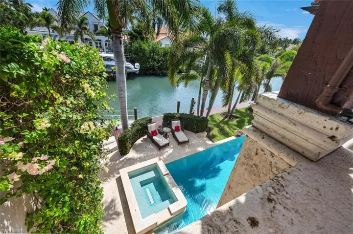View of swimming pool with a pool with connected hot tub, a water view, and a patio
