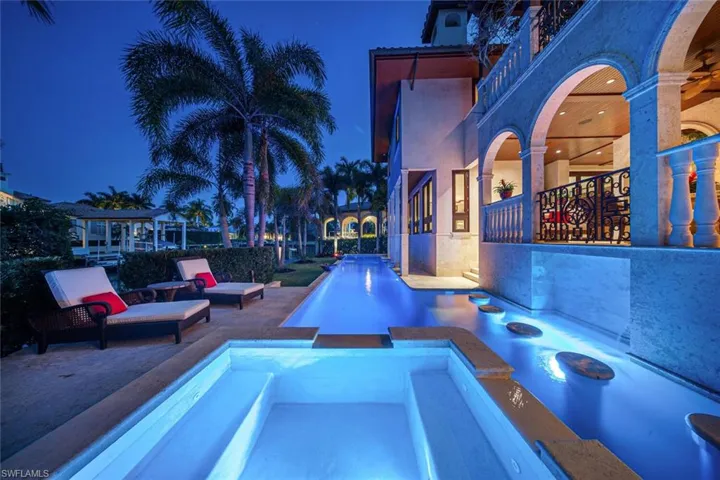 View of pool with a patio and a pool with connected hot tub