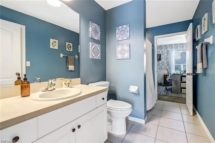 Bathroom featuring vanity, tile patterned flooring, and curtained shower