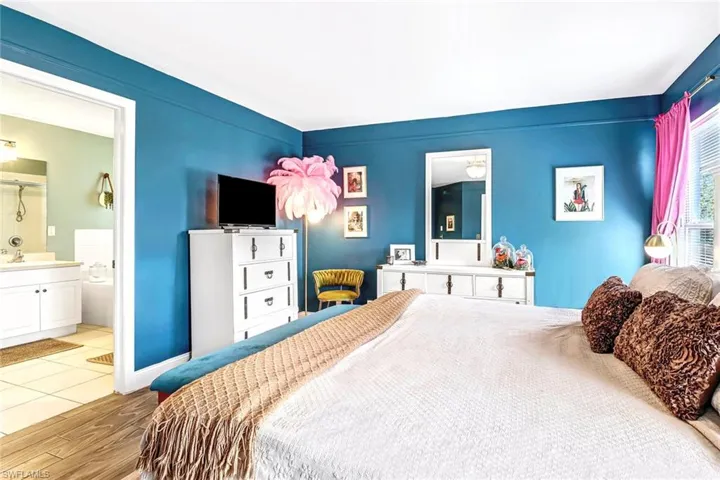 Bedroom featuring wood finished floors and ensuite bath