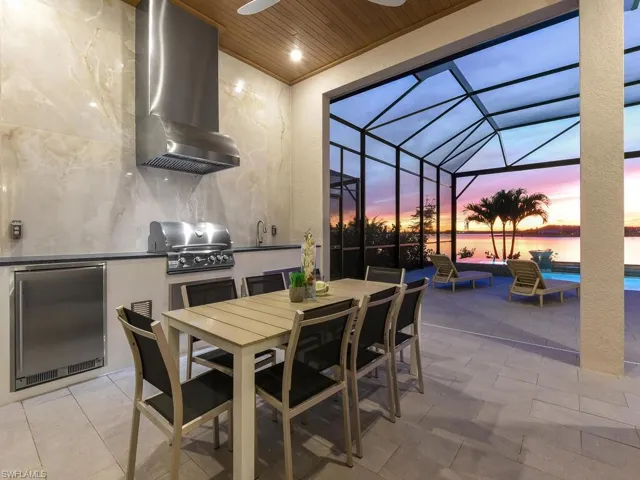 Fully custom summer kitchen w/ large format porcelain tile backsplash to ceiling, White Glass Tile on Wall, & Faux Wood Ceiling