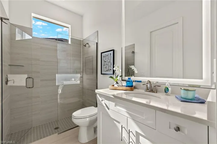 Guest Bathroom with Quartz Counter, Custom Mirror to Ceiling, Walk-in Tile Shower & Framless Shower Door