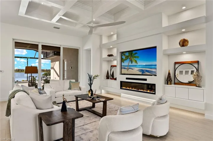Modern built-in (features an electric fireplace, floating custom cabinets, recessed TV & sound bar) & Custom Tray Ceiling in great room.