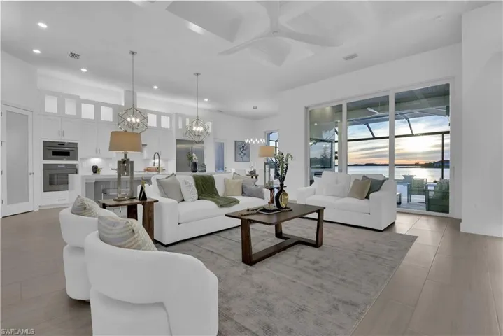 Gourmet Kitchen w/ luxury Thermador appliances, gas cooktop, luxury white cabinetry plus lighted upper cabinets, quartz counters & backsplash w/ oversized waterfall countertop on island, & walk-in pantry w/ frosted glass door