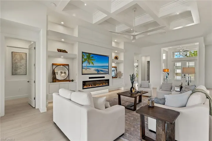 Modern built-in (features an electric fireplace, floating custom cabinets, recessed TV & sound bar) & Custom Tray Ceiling in great room.