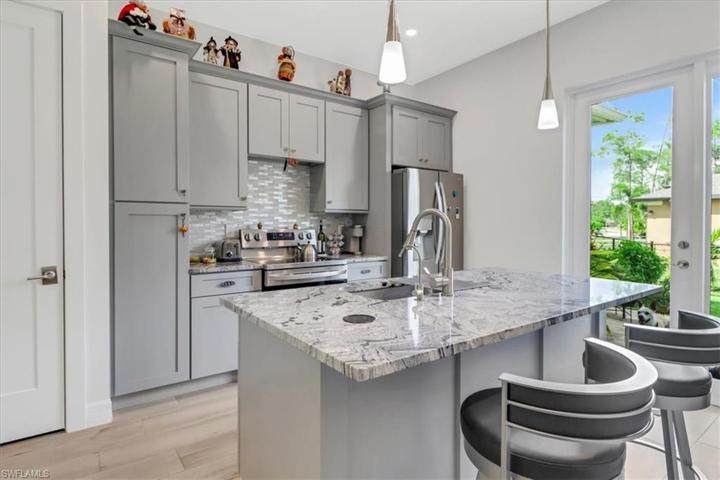 Guest Suite 1 - Kitchen Up Close View Features a French-Door Refrigerator, Stove, Cooktop, Sink & Cabinetry.